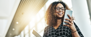 A financial professional using her phone to do business with Protective
