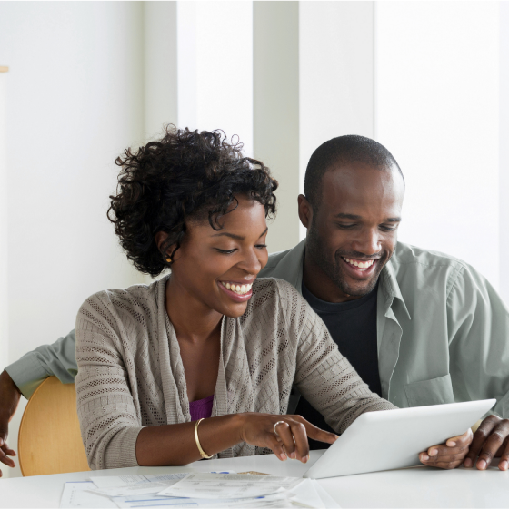 A husband and wife using a table to review information about indexed universal life insurance.
