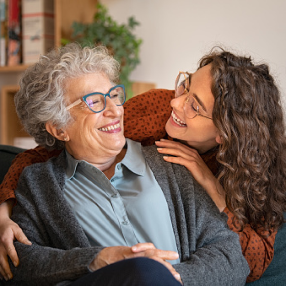 Mother smiling at daughter knowing life insurance will one day help relieve financial stress for her beneficiaries.