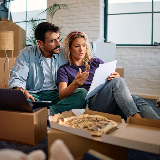 Couple reviews life insurance coverage costs while enjoying a pizza.
