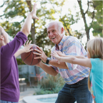 A man playing basketball with his two grandchildren knowing he has a protected legacy plan.