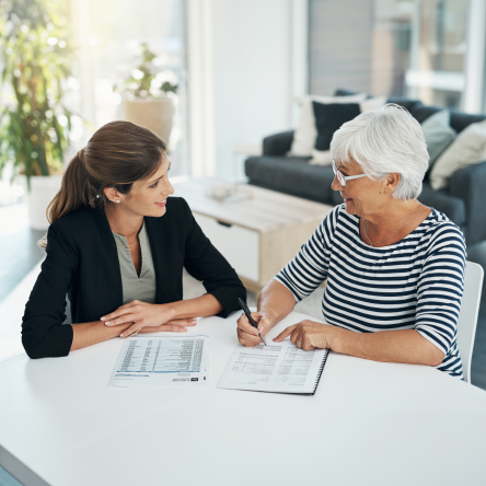 A financial professional meeting with senior-aged female client to review an estate plan.
