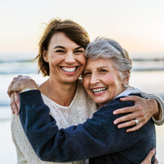 Woman who represents a potential Protective Series Balance client enjoys a walk on the beach with her daughter.