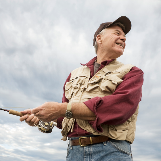 A man smiling while fishing, knowing he is protected with whole life insurance.