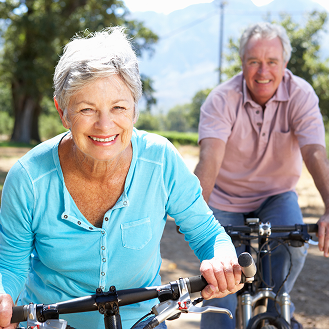 Retired couple enjoying a bike ride after securing their income.
