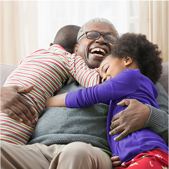 A grandfather happily hugging his grandchildren, knowing his family his protected with whole life insurance.